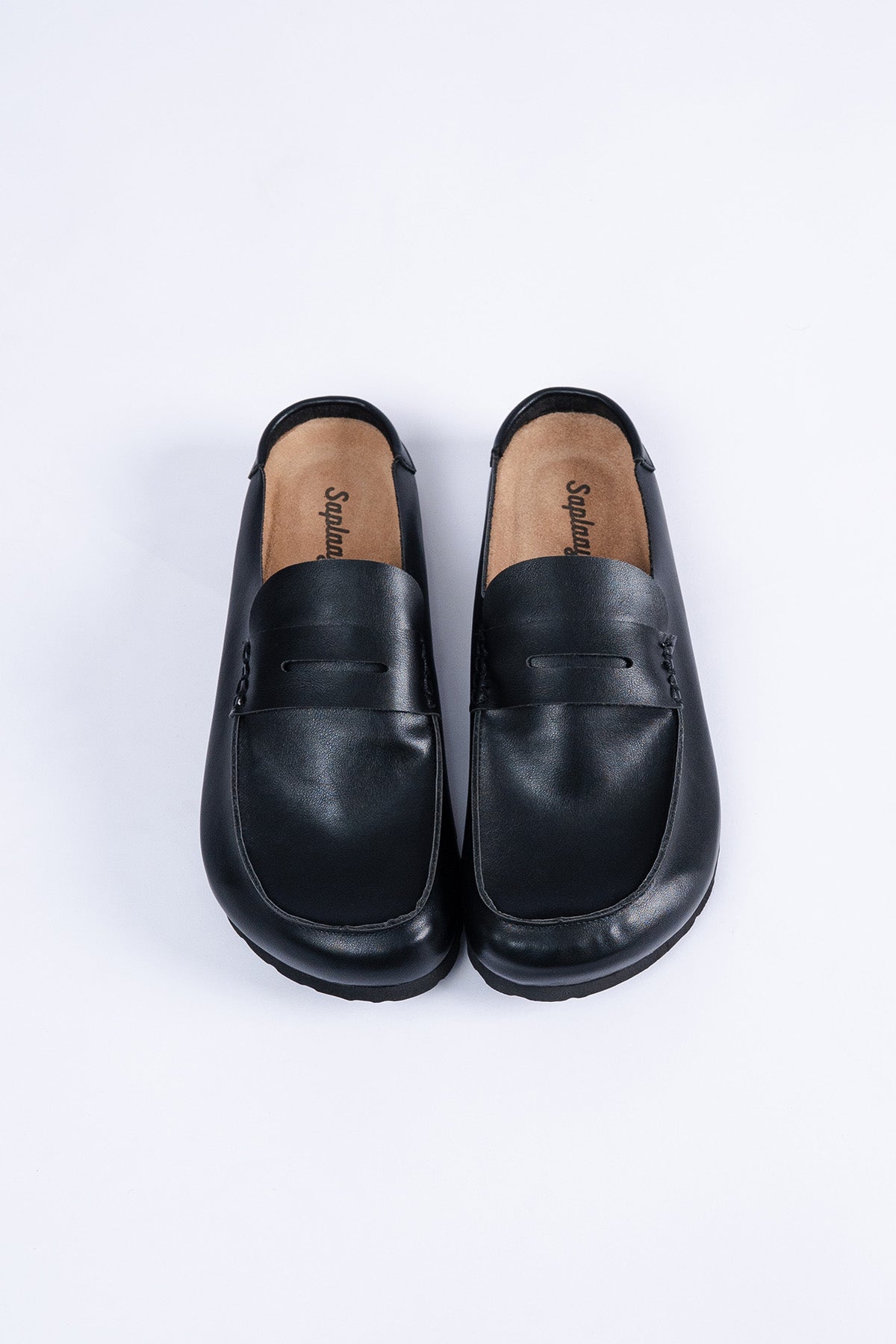 Saaplay Birkener Moccas in black leather, showcasing classic moccasin design with detailed stitching and a comfortable sole.
